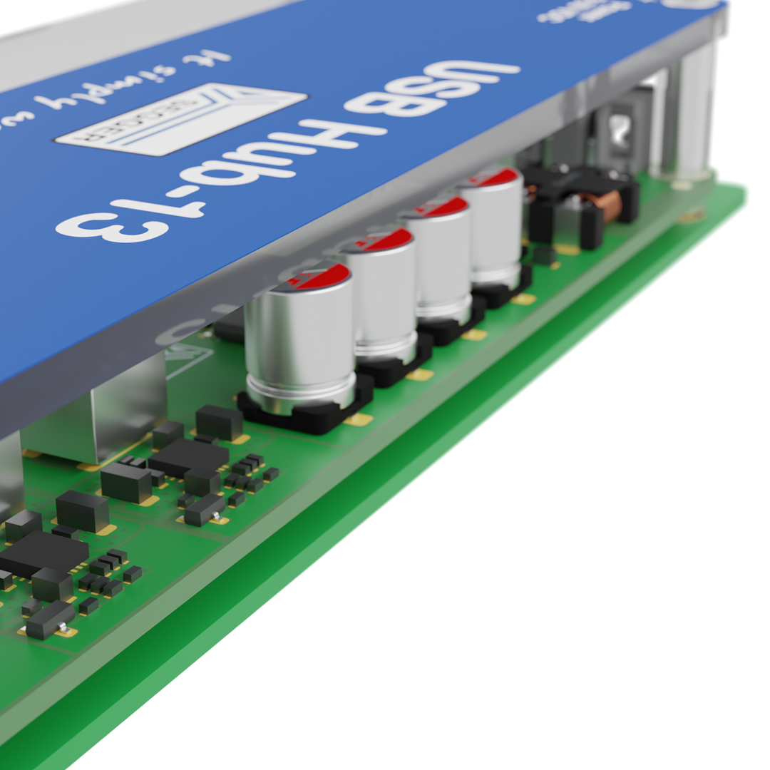 A USB hub with a blue top label marked "USB HUB-13." It features multiple metallic cylindrical components and various small electronic circuits visible on a green base. The hub likely serves to connect multiple USB devices.